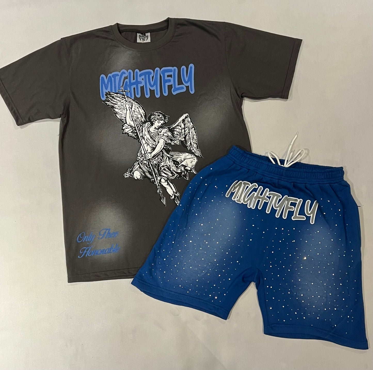 Dark Gray t-shirt with 'Mighty Fly' and an angel design and blue shorts with 'Mighty Fly' text on a light gray background with rhinestones