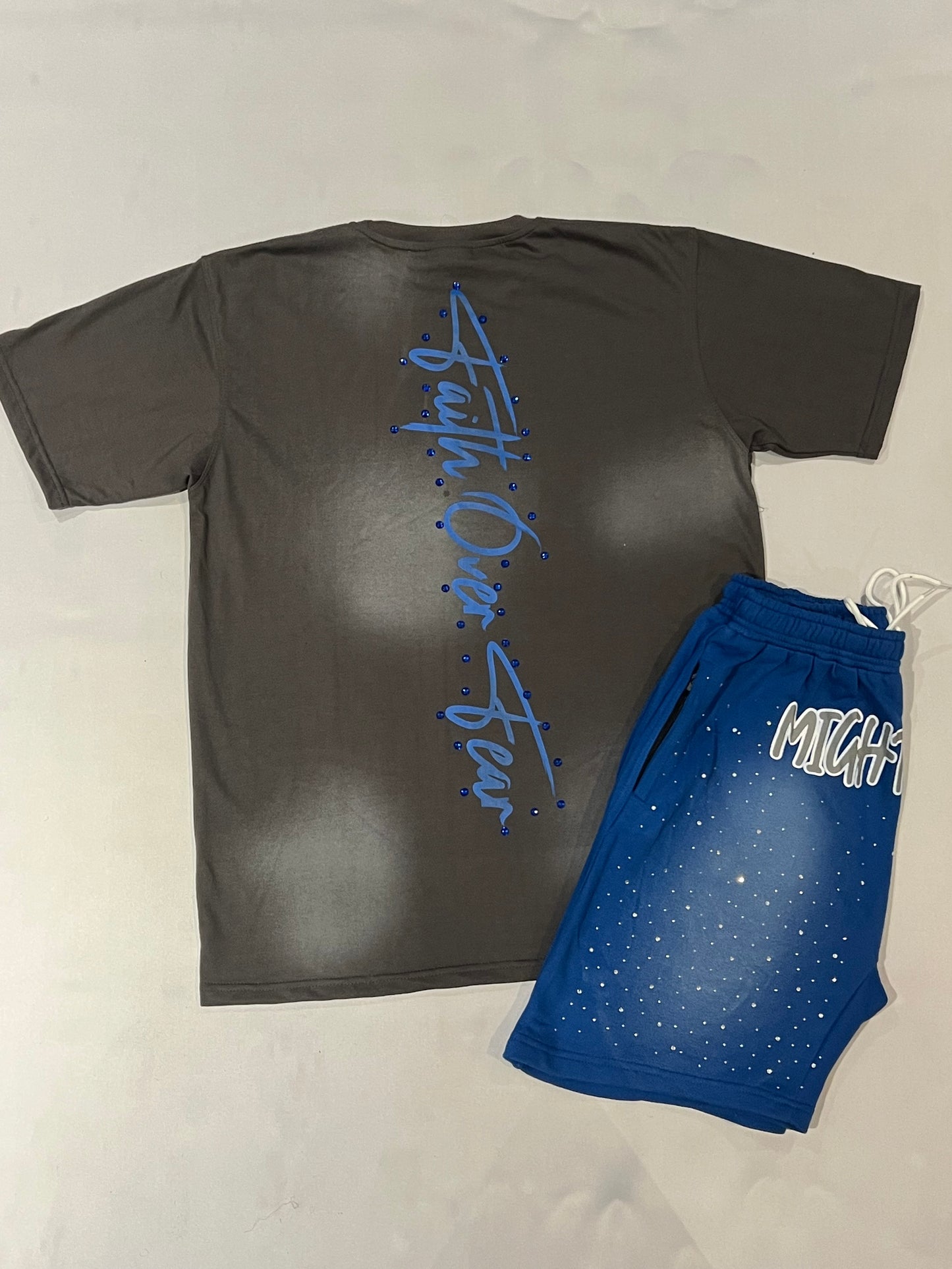 Back side Dark gray shirt with 'Faith Over Fear' text and blue shorts on a light gray background